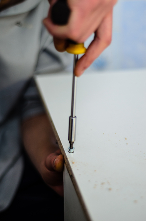 Worker assemble chipboard furniture with the screwdriverの写真素材