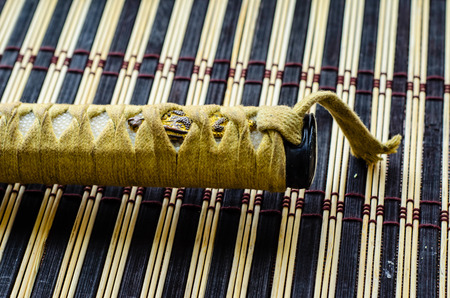 Handle of the japanese sword katana on a bamboo matの写真素材