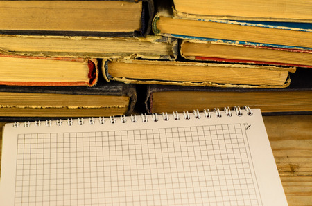 Notepad and glasses in front of many booksの写真素材