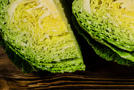 Quarters of the savoy cabbage on wooden tableの写真素材