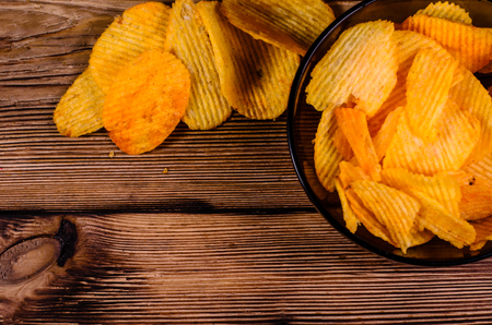 Potato chips in glass bowl on rustic wooden table.Top viewの写真素材