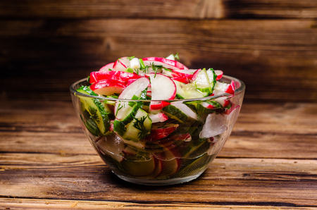 Vegetarian salad with radish and cucumbers in glass bowlの写真素材