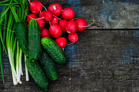 Radish cucumbers and green onion on rustic wooden table. Top viewの写真素材