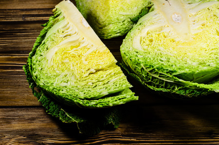 Quarters of the savoy cabbage on wooden tableの写真素材