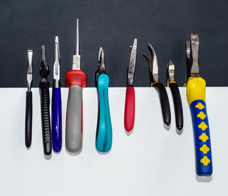 Different nippers and pliers on a white chipboard