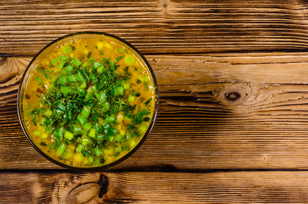 Vegetable soup in glass bowl on wooden table. Top viewの写真素材