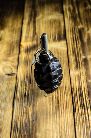 Black hand grenade on the wooden tableの写真素材