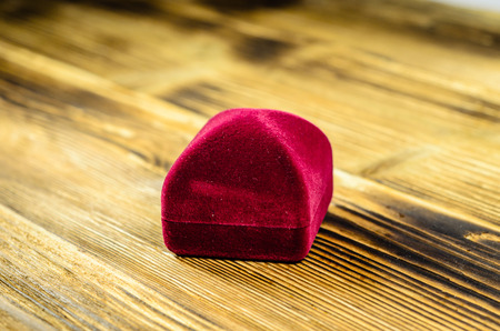 Red velvet jewelry box  on a wooden tableの写真素材