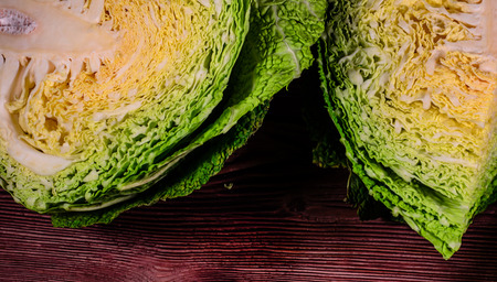 Quarters of the savoy cabbage on wooden tableの写真素材