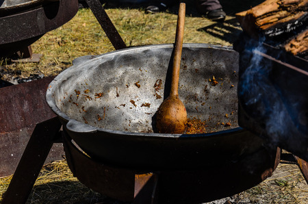 Wooden spoon in a big black cauldronの写真素材