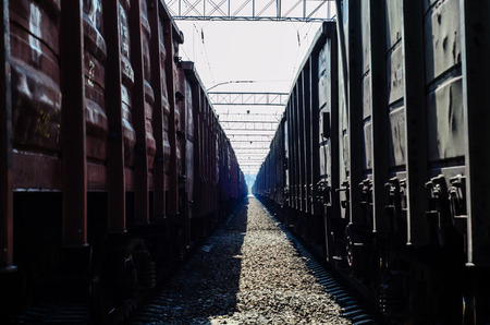 View between two cargo trains on cloudy dayの写真素材