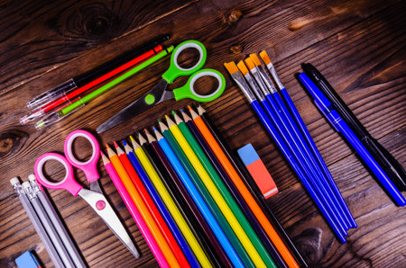 Set of different school stationeries. Pens,  scissors, pensils, erasers, paintbrushes on rustic...