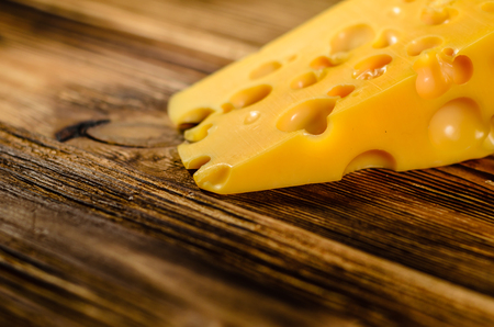 Piece of cheese on rustic wooden table. Selective focusの写真素材