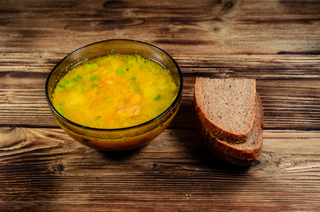 Vegetable soup in glass bowl on wooden tableの写真素材