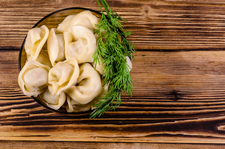 Fresh dumplings in a glass bowl on wooden table. Top viewの写真素材