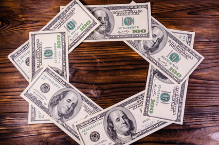 Frame of the one hundred dollars bills on rustic wooden table. Top viewの写真素材
