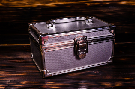 Aluminium make-up case or jewellery accessories box on wooden backgroundの写真素材
