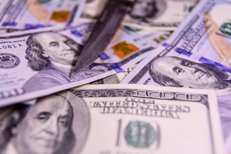 Flick knife on one hundred dollar billsの写真素材