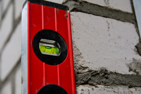 Checking the level of brick wall with waterpas