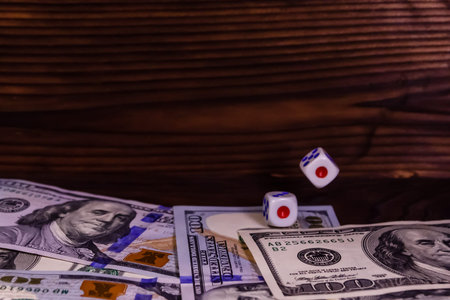 Dice in flight above the one hundred dollar bills. Gamble concept