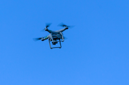 White drone flying in a blue skyの写真素材