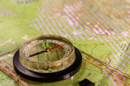 Touristic magnetic compass lying on topographical mapの写真素材