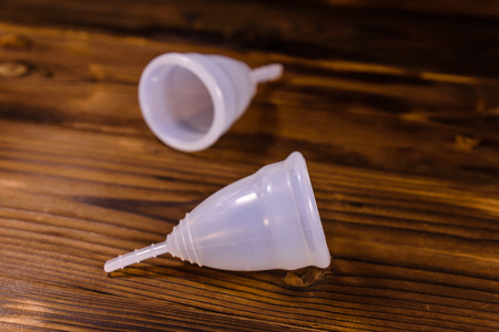 Two menstrual cups on rustic wooden tableの写真素材