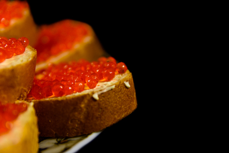Sandwiches with red caviar isolated on black backgroundの写真素材
