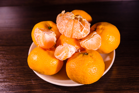 Plate with mandarins on dark wooden tableの写真素材
