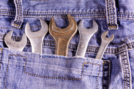 Different wrenches in a pocket of the blue jeans. Top viewの写真素材