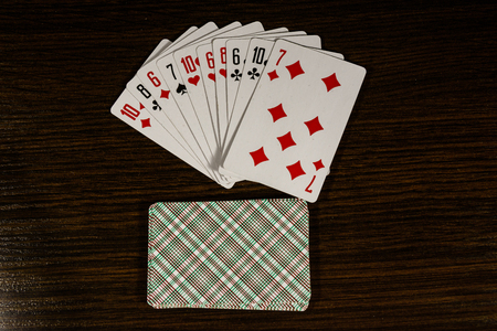 Playing cards on a dark wooden table. Top viewの写真素材