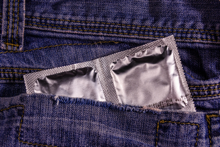 Condoms in a pocket of blue jeansの写真素材