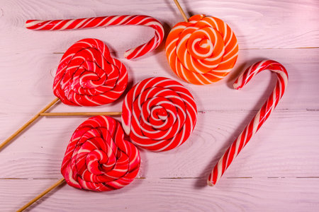 Different sweet lollipops on a rustic wooden table. Top view