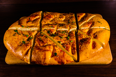 Sliced pita bread with garlic on wooden cutting boardの写真素材