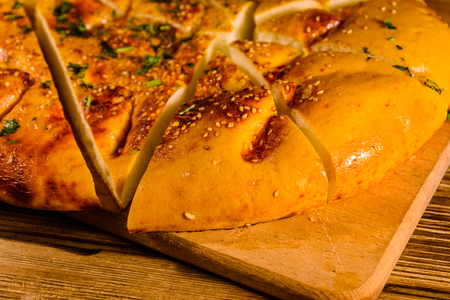 Sliced pita bread with garlic on wooden cutting boardの写真素材