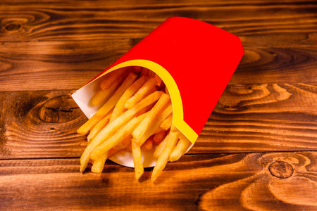 French fries in red box on rustic wooden table