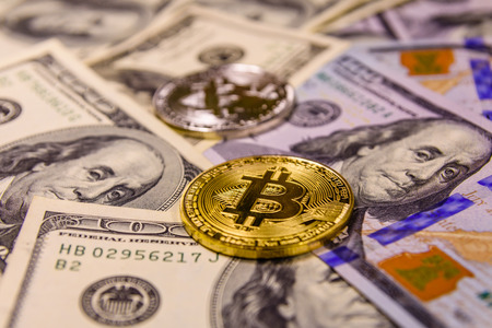 Bitcoins on a one hundred dollar billsの写真素材
