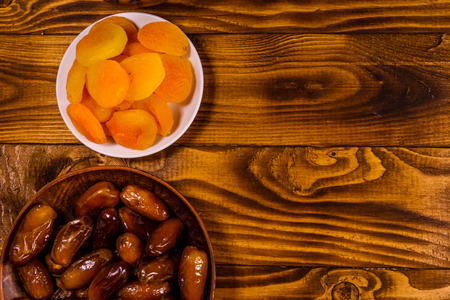 Date fruits and dried apricots on rustic wooden table. Top viewの写真素材