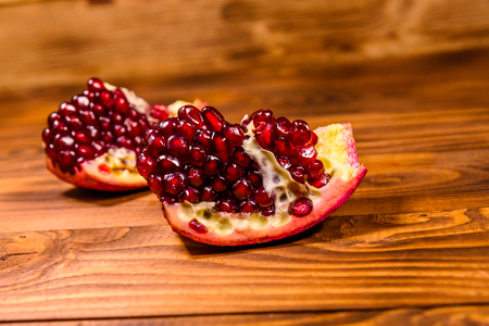 Pieces of the garnet fruit on rustic wooden tableの写真素材