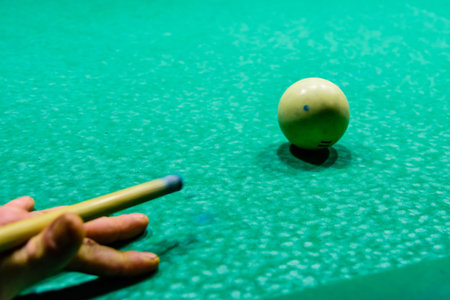 Player arm with the cue and balls on a green cloth. Russian billiard