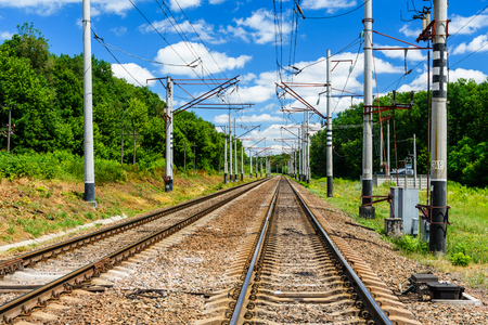 View on a railroad track and white clouds in a blue skyの写真素材