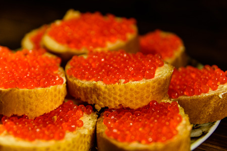 Sandwiches with red caviar on rustic wooden tableの写真素材
