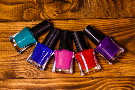 Different nail polishes on rustic wooden table. Top viewの写真素材