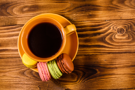 Cup of coffee and french macaroons on rustic wooden table. Top viewの写真素材