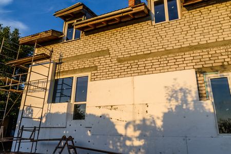Insulation of house with styrofoam. Scaffold on buildingのeditorial素材