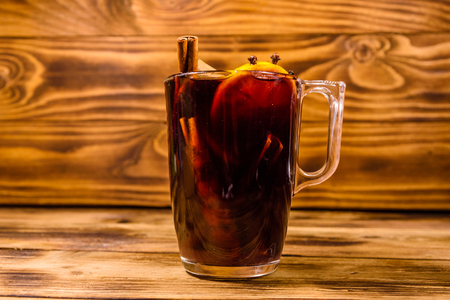 Cup of mulled wine with cinnamon on rustic wooden tableの写真素材