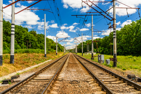 View on a railroad track and white clouds in a blue skyの写真素材