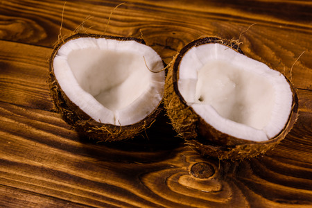 Ripe halved coconut on rustic wooden tableの写真素材