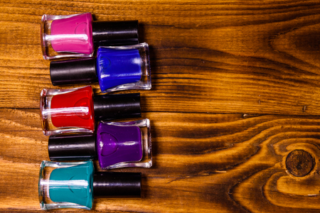 Different nail polishes on rustic wooden table. Top viewの写真素材