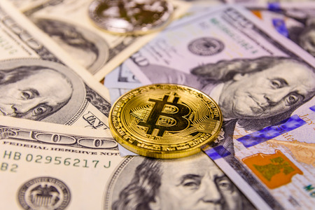 Bitcoins on a one hundred dollar billsの写真素材